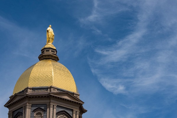 A close-up of Mary on the Golden Dome with blue sky behind